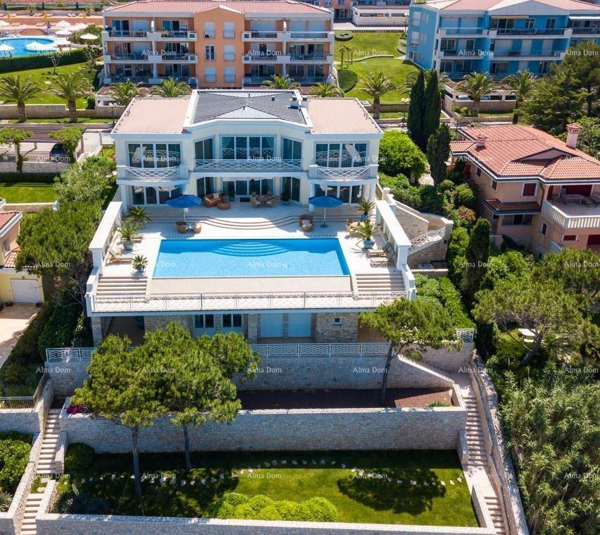 Weitläufige Villa mit großem Pool und Terrassen, eingebettet in eine grüne Landschaft mit Meerblick.