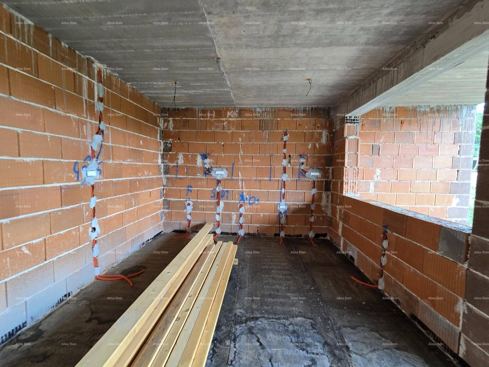 Innenraum im Rohbau mit Ziegelwänden, vorbereiteten Elektroinstallationen und Holzlatten auf dem Boden.