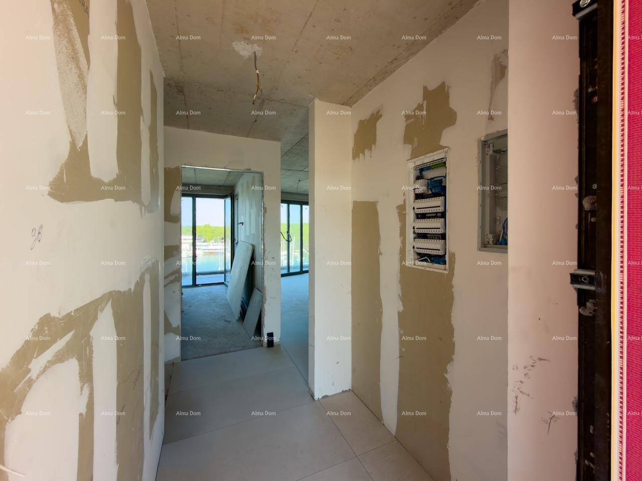 Flur im Rohbau mit unverputzten Wänden und Blick auf den Yachthafen durch die Fenster.