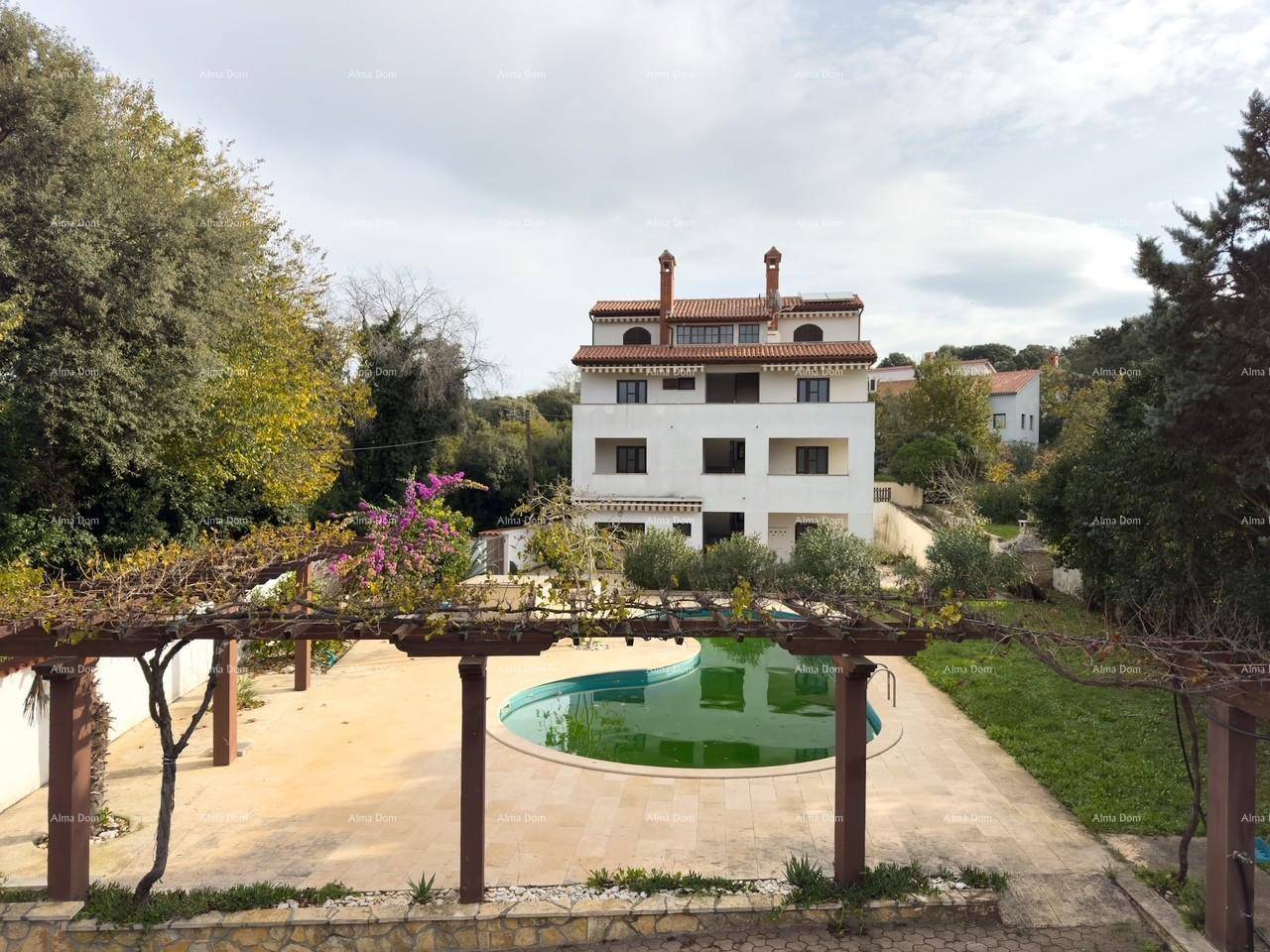 Gesamtansicht des Anwesens mit dem Hauptgebäude, dem Pool und der Pergola, eingebettet in grüne Landschaft.