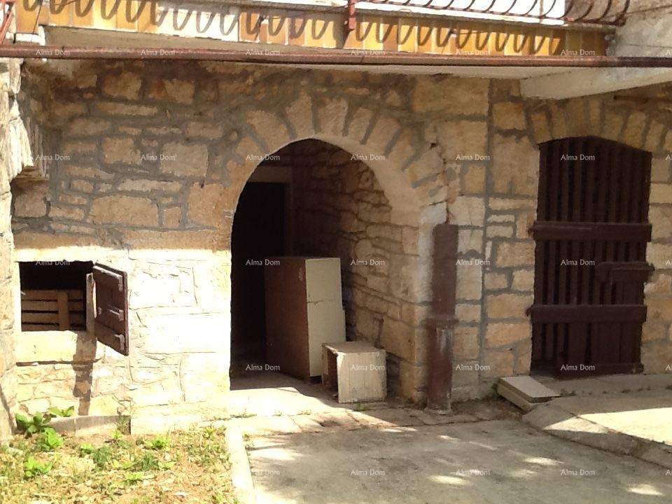 Erdgeschoss eines alten Steinhauses mit gemauerten Bögen und rustikalen Holztüren.