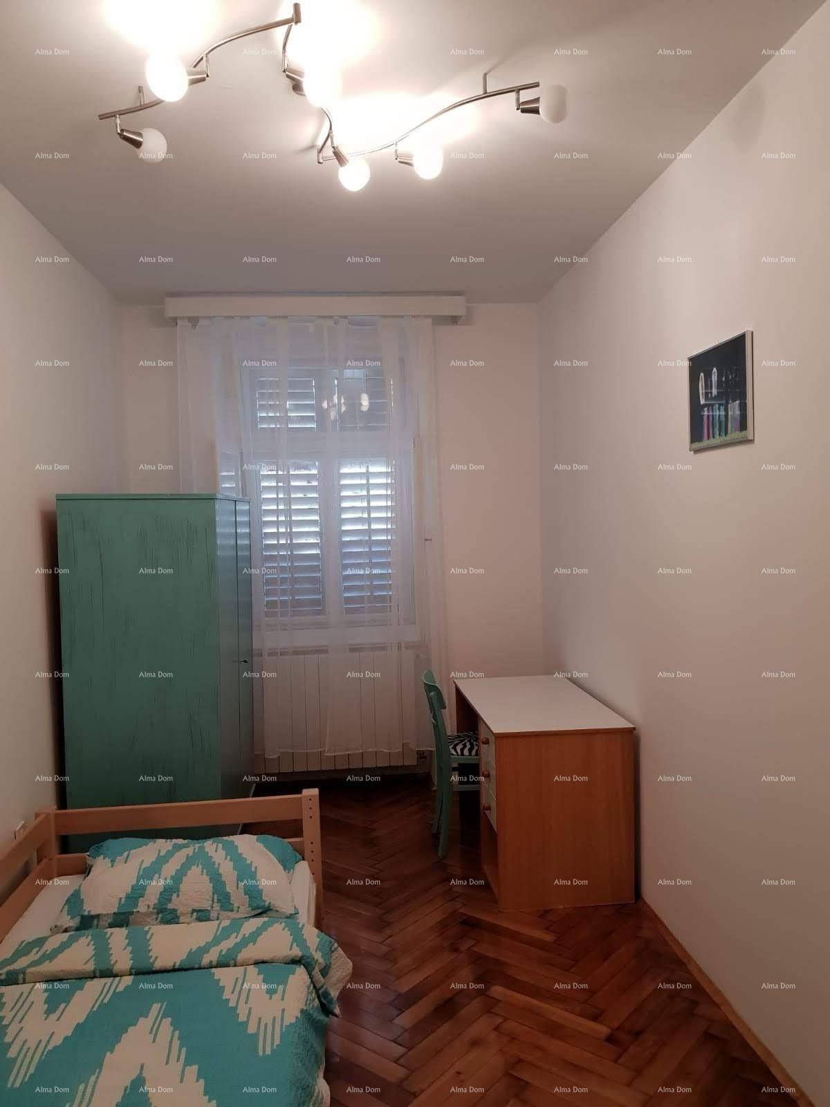 Helles Schlafzimmer mit Einzelbett, Schreibtisch und großem Fenster für eine angenehme Lernumgebung.