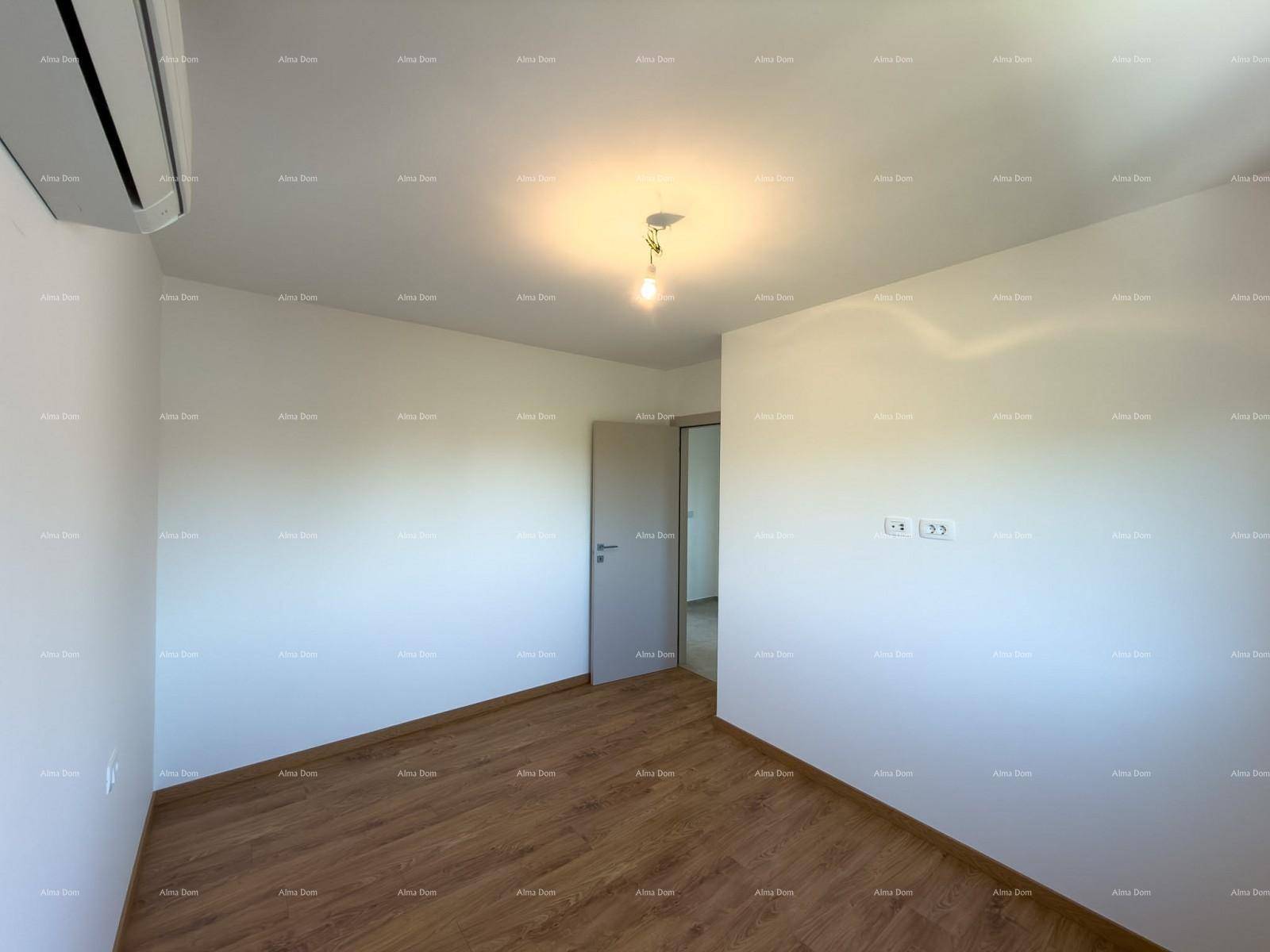 Geräumiges Schlafzimmer mit Holzfußboden, Klimaanlage und Zugang zu einem weiteren Raum.