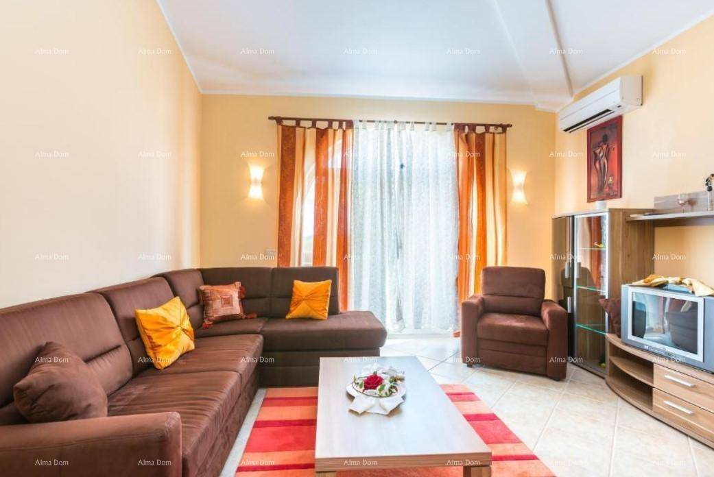 Gemütliches Wohnzimmer mit Ecksofa, Fernseher und Klimaanlage.