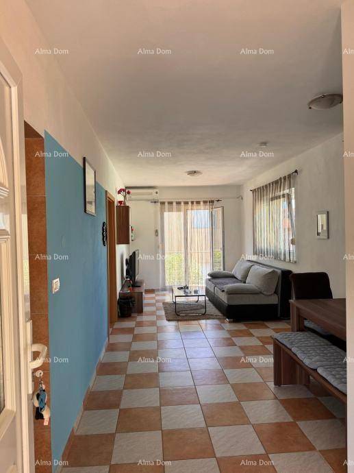 Offener Wohn- und Essbereich mit Sofa, Esstisch und Zugang zu einem Balkon.