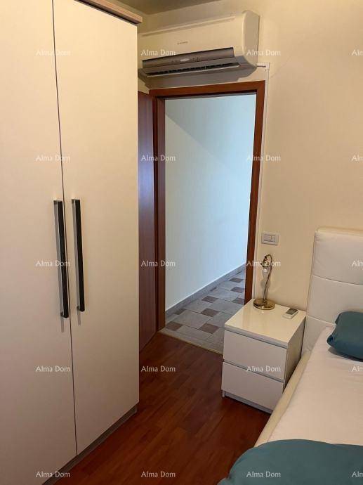 Schlafzimmer mit weißem Kleiderschrank, Nachttisch und installierter Klimaanlage.