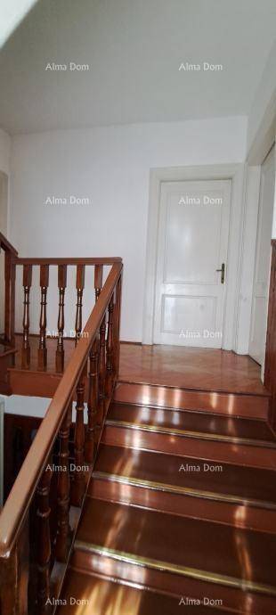 Holztreppe mit Geländer und weißer Tür, die zu weiteren Räumen führt.