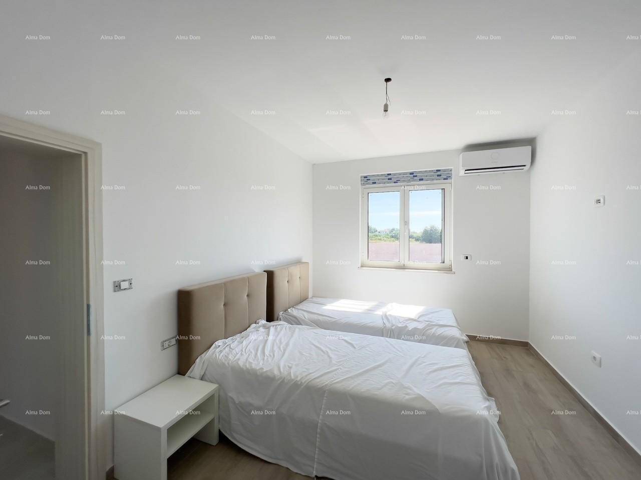 Helles Schlafzimmer mit zwei Einzelbetten, Nachttisch und Fenster mit Blick ins Grüne.