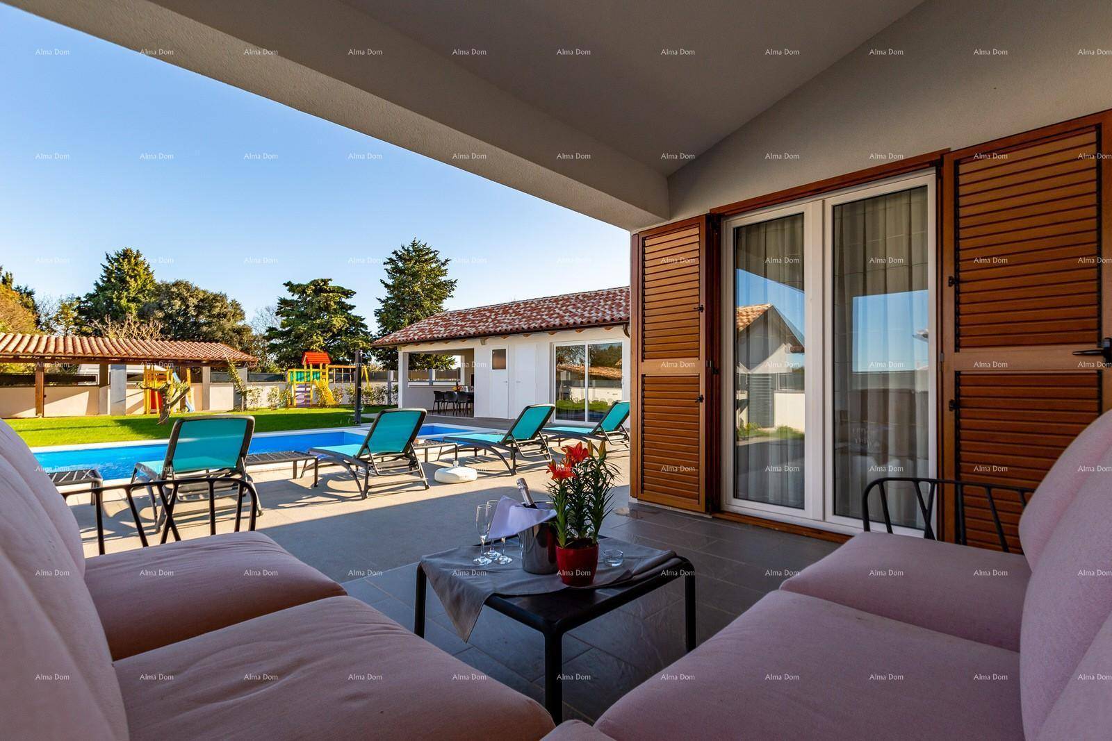 Überdachte Terrasse mit bequemen Lounge-Möbeln und Blick auf den Poolbereich und Spielplatz.