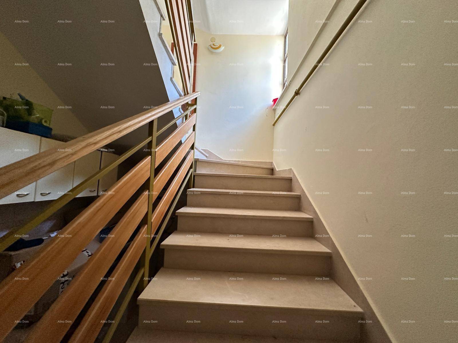 Heller Treppenaufgang mit Holzgeländer und hellen Stufen, der die Etagen verbindet.