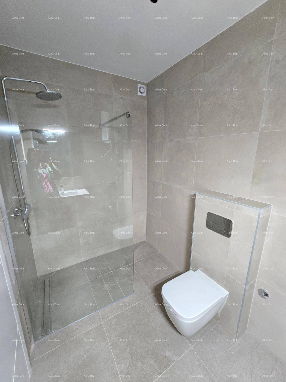 Zeitgemäßes Badezimmer mit begehbarer Dusche, Wand-WC und grauen Fliesen, sehr gepflegt.