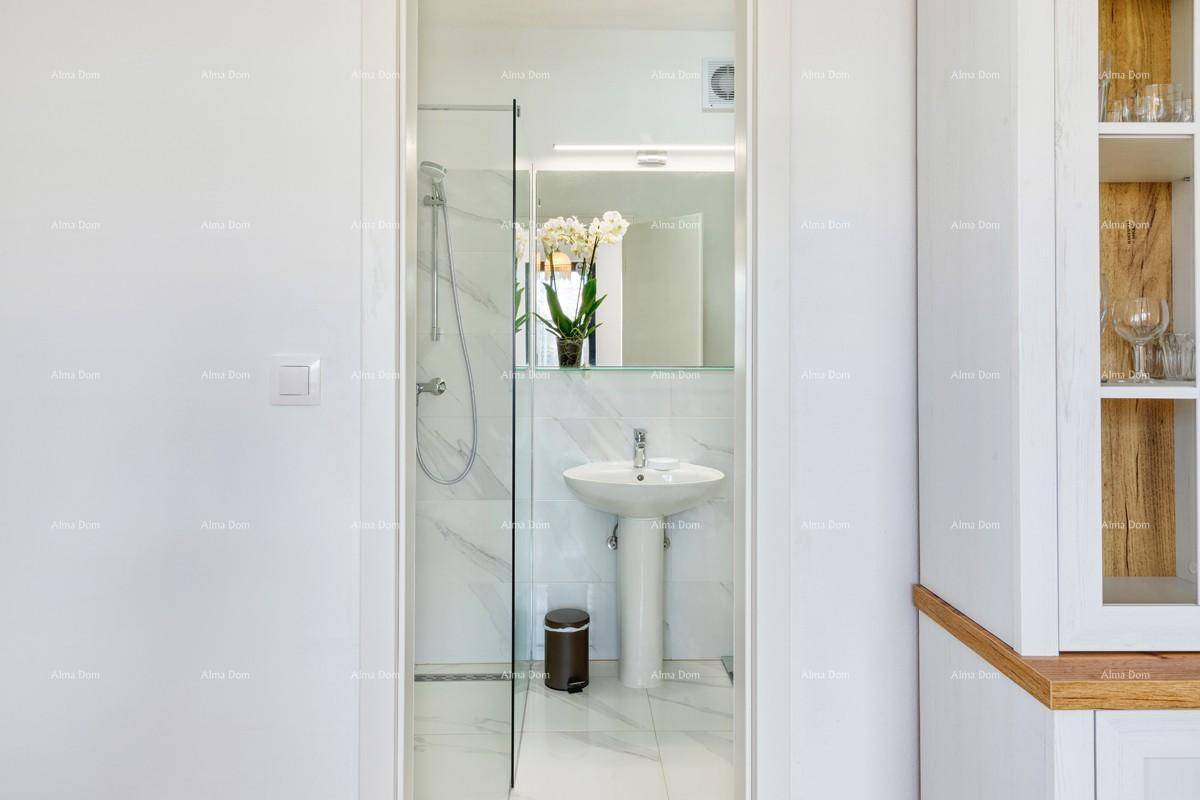 Modernes Badezimmer mit begehbarer Dusche und elegantem Waschtisch, sichtbar durch die Türöffnung.