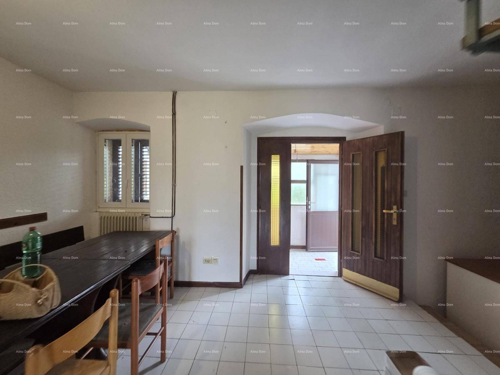 Esszimmer mit großem Holztisch und Stühlen, Fliesenboden und Fenster mit Fensterläden.