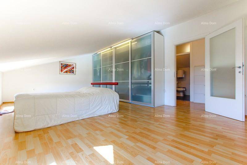 Helles Schlafzimmer im Dachgeschoss mit Holzfußboden und großem Kleiderschrank.