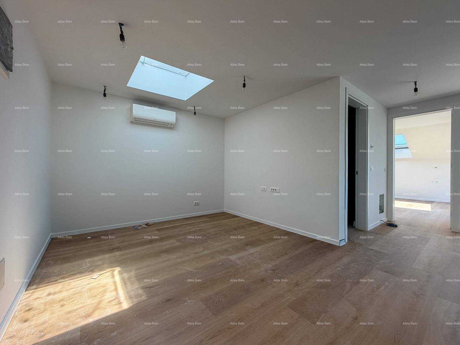 Helles Schlafzimmer mit Holzboden, Dachfenster und Klimaanlage.