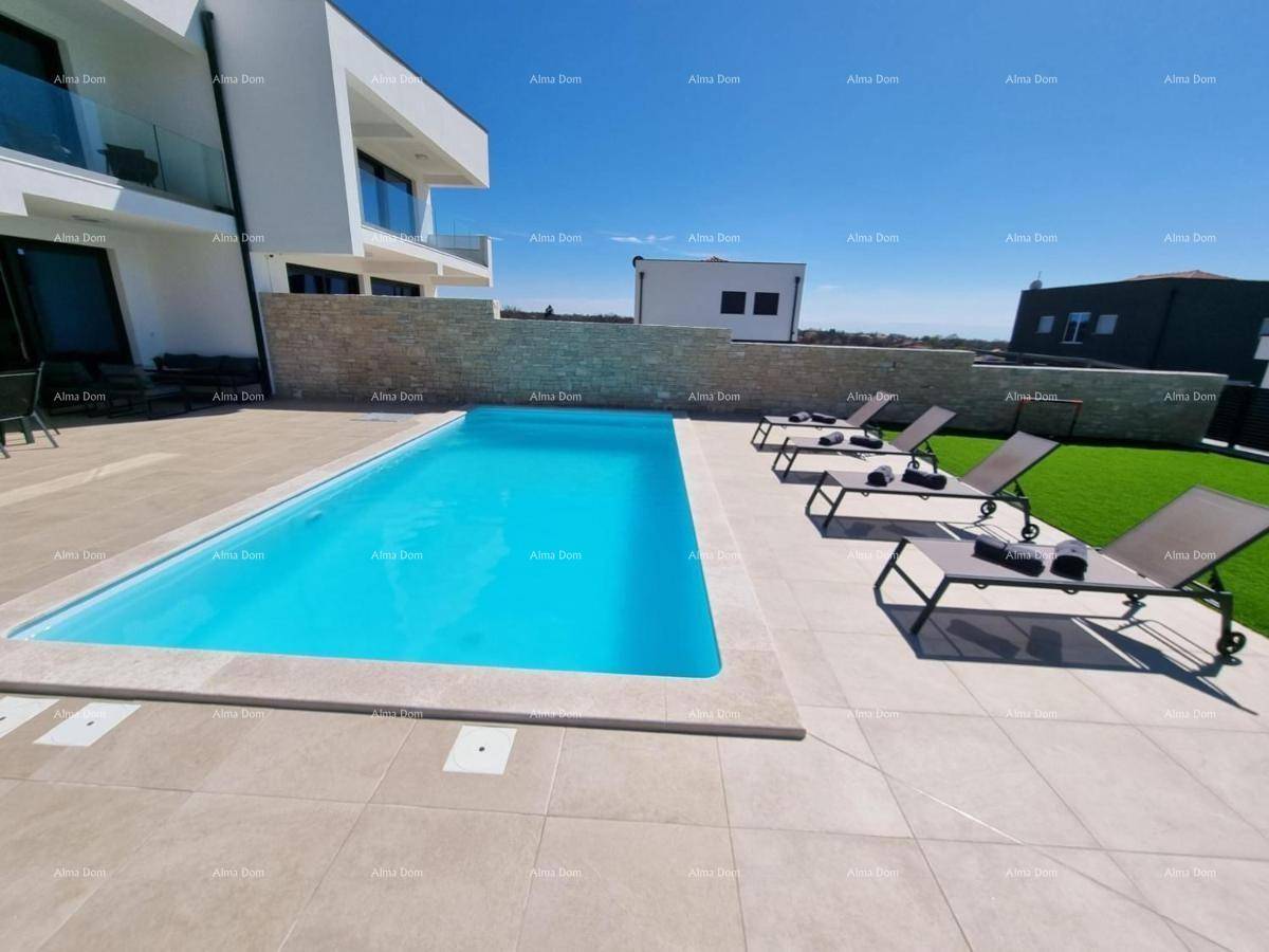 Außenbereich mit Pool, Liegestühlen und der modernen Architektur der Villa unter blauem Himmel.