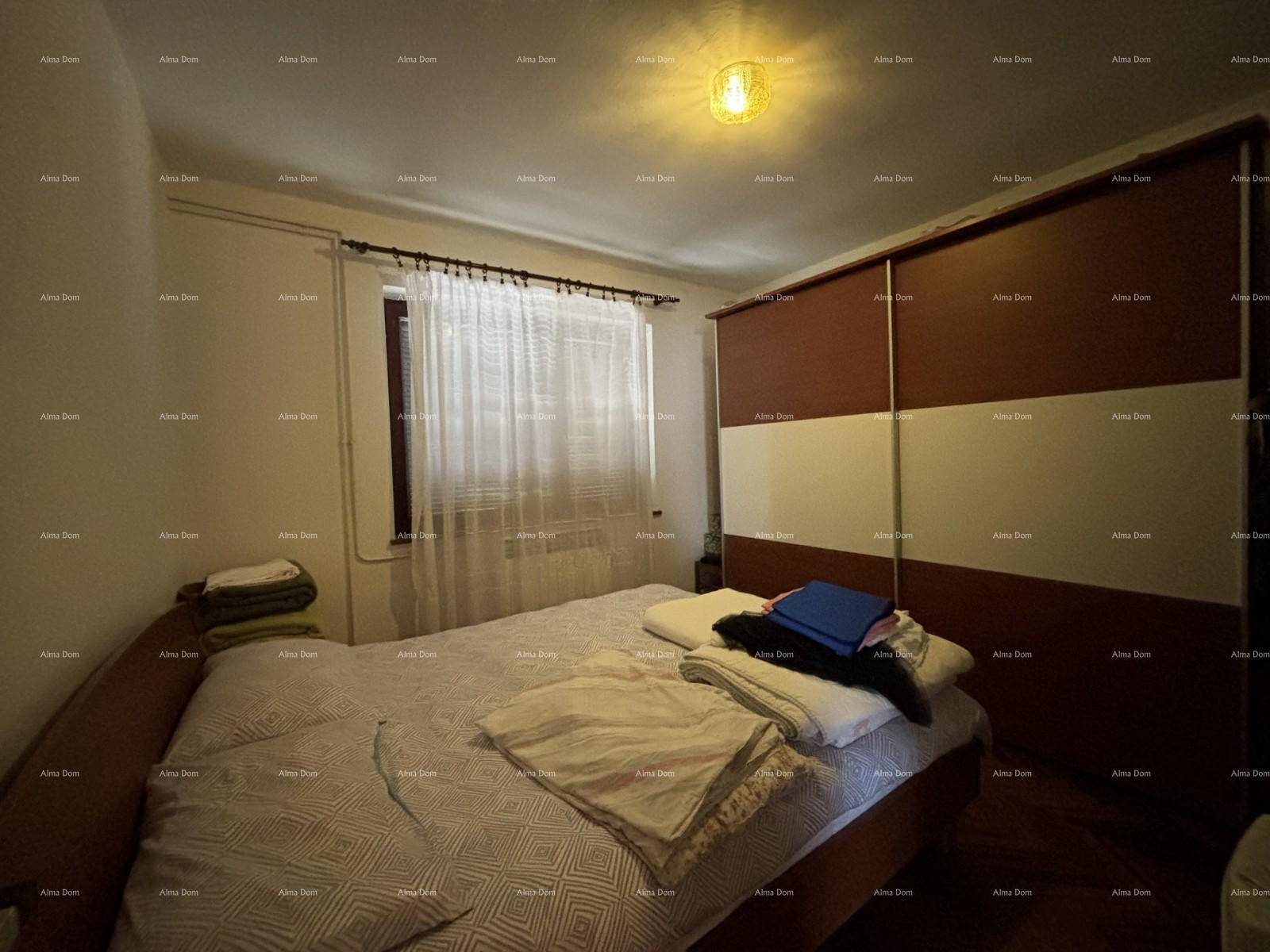 Schlafzimmer mit Doppelbett, großem Schiebeschrank und Fenster.