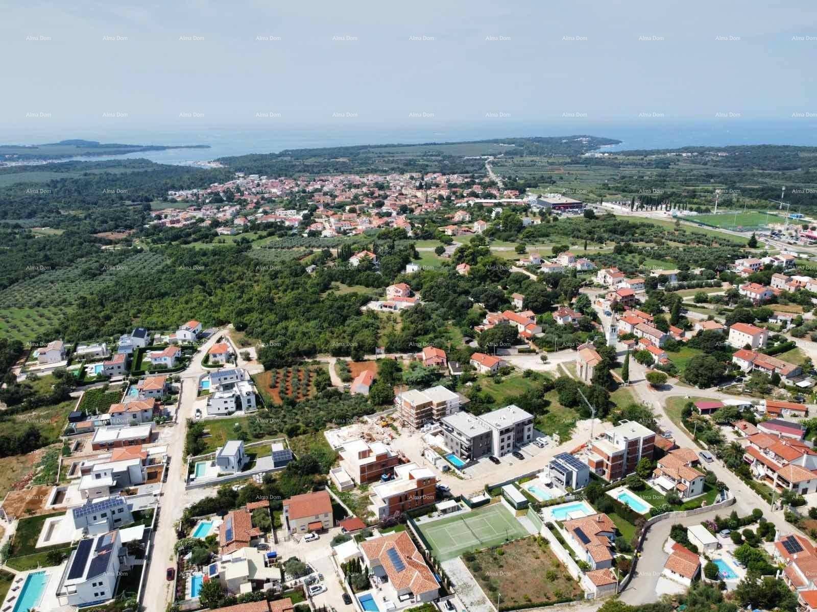 Weitläufige Luftaufnahme der Wohngegend mit Blick auf das Meer und viel Grün.