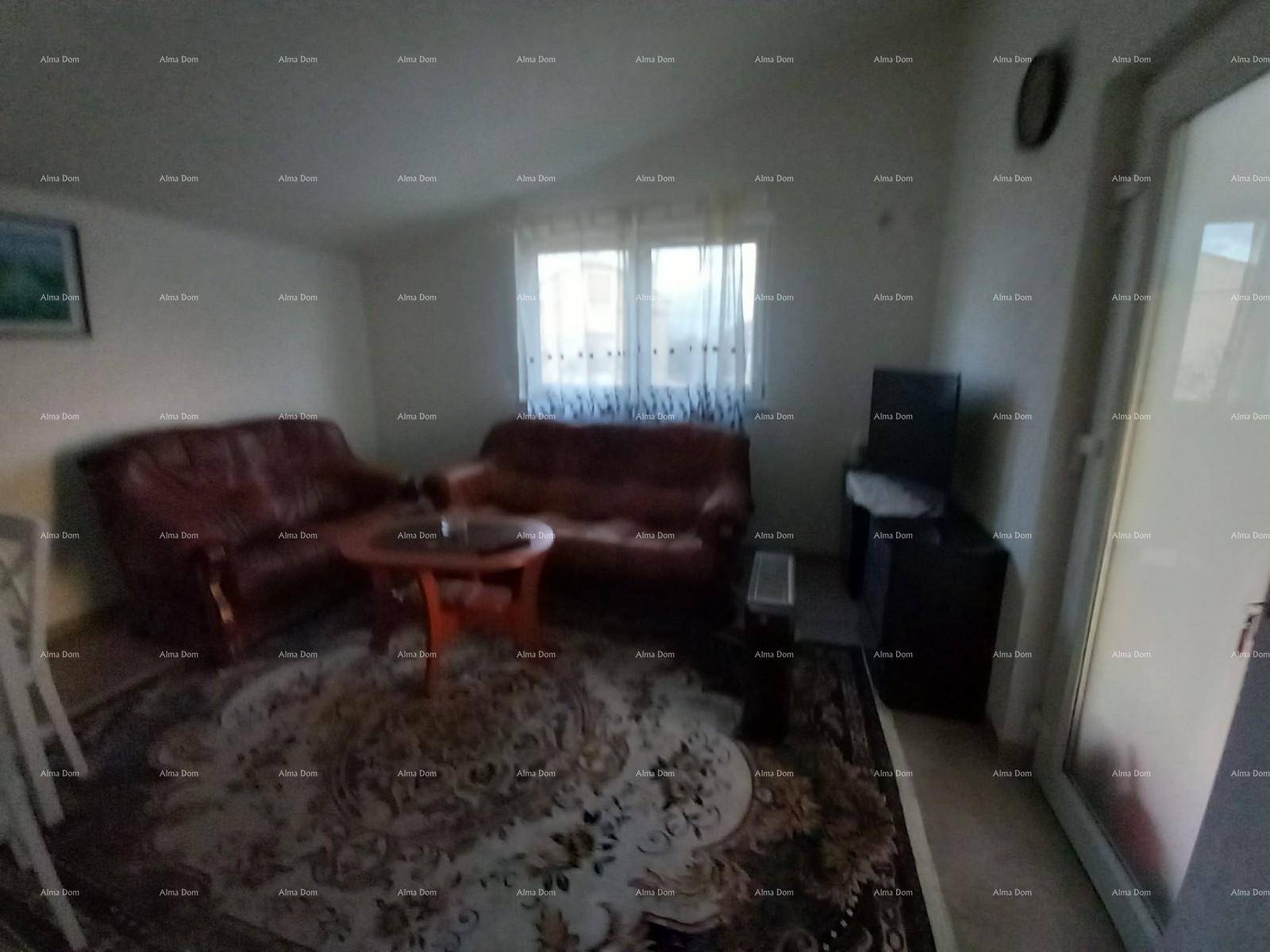 Gemütliches Wohnzimmer im Dachgeschoss mit Ledersofas, Teppich und Zugang zu einem Balkon.