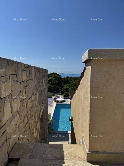 Blick von der Steintreppe auf den Poolbereich und das Meer in der Ferne.