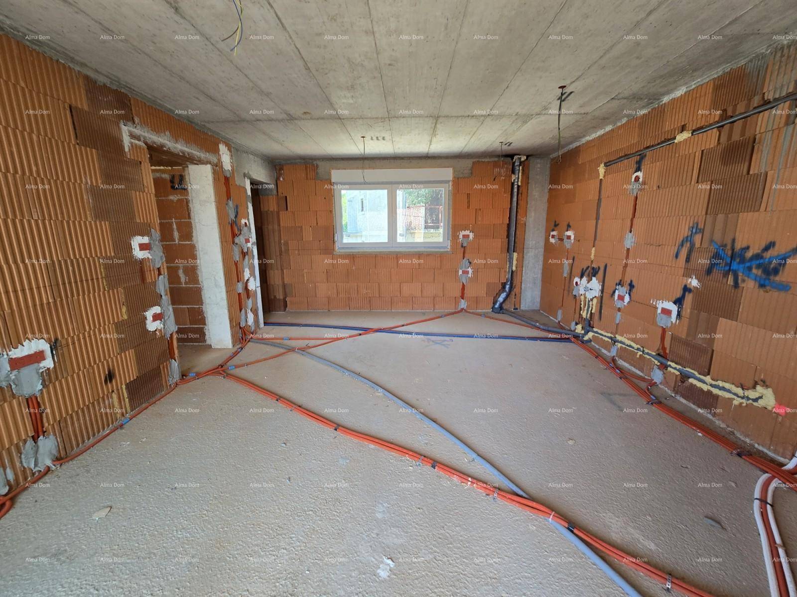 Geräumiger Wohnbereich im Rohbau mit Ziegelwänden, Fenstern und sichtbaren Installationen.