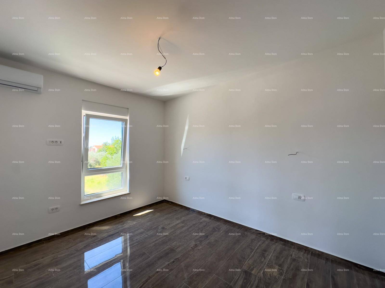 Helles Schlafzimmer mit dunklen Fliesen und einem großen Fenster, das viel Tageslicht hereinlässt.