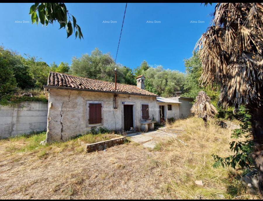 Verfallenes Landhaus mit traditionellem Ziegeldach und rissiger Steinfassade in sonniger Lage.