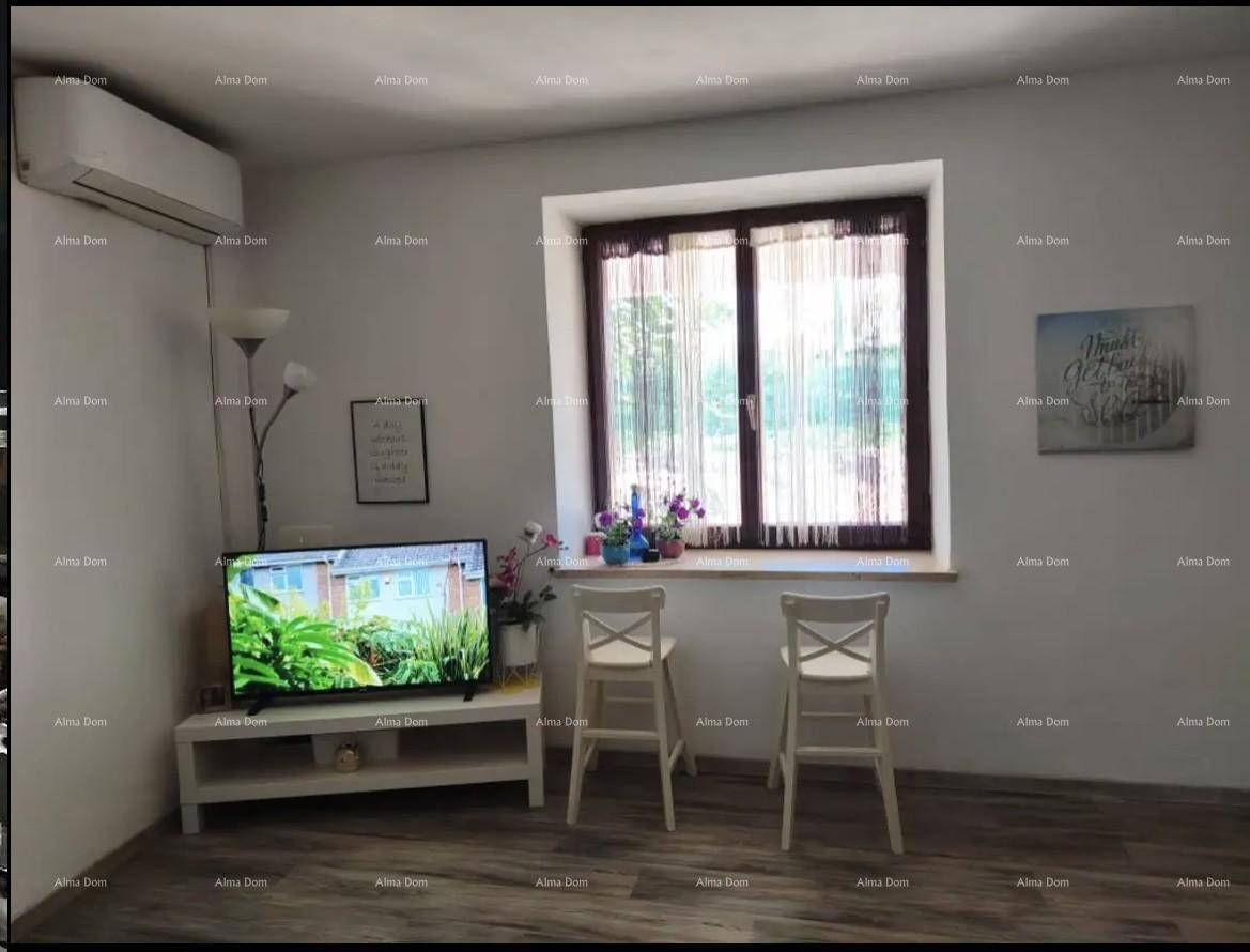 Gemütlicher Wohnbereich mit Klimaanlage, Fenster und zwei Stühlen, bietet Komfort und Tageslicht.