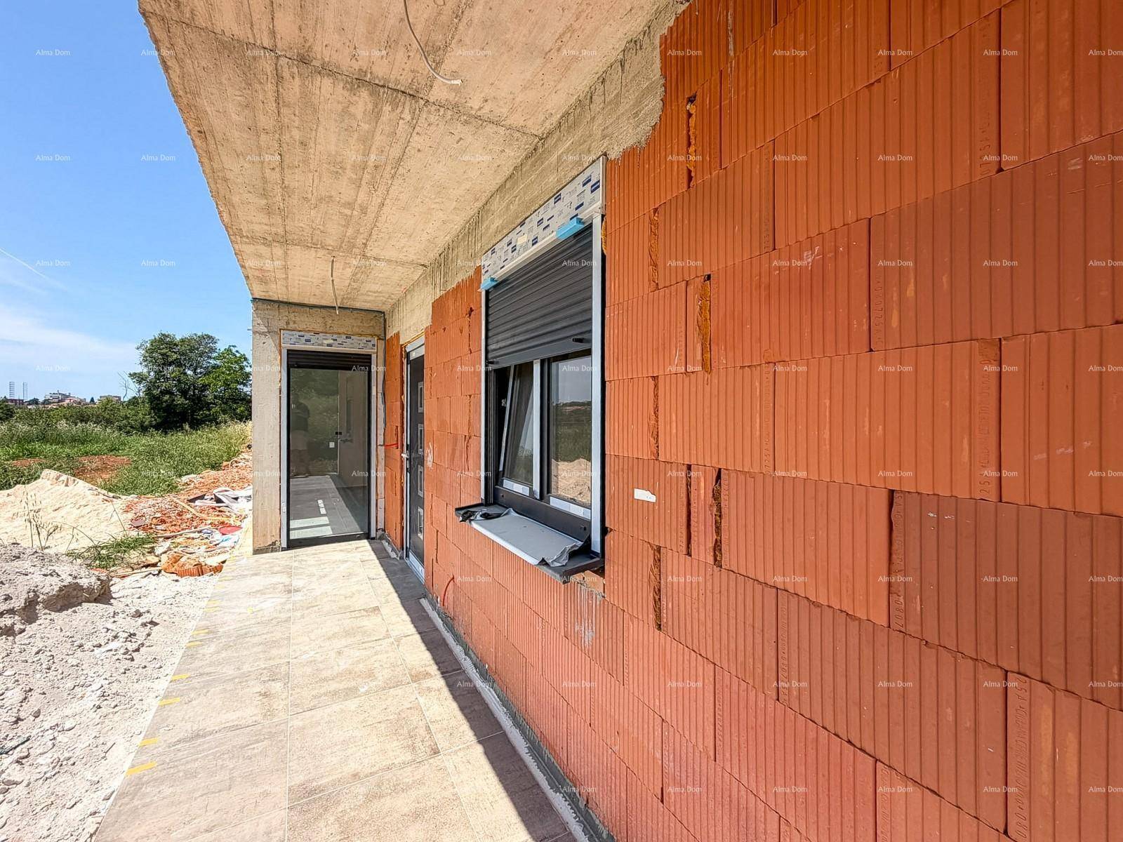 Detailansicht der Ziegelwand und des Fensters mit Rollladen am Neubau.