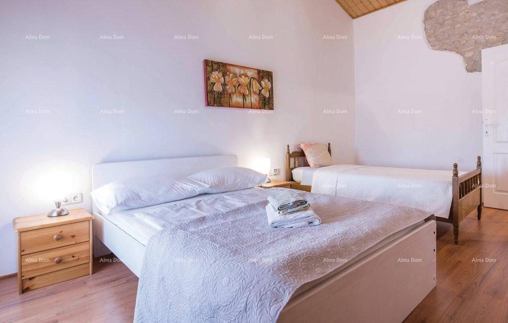 Schlafzimmer mit zwei Betten, Holzboden und traditioneller Einrichtung.