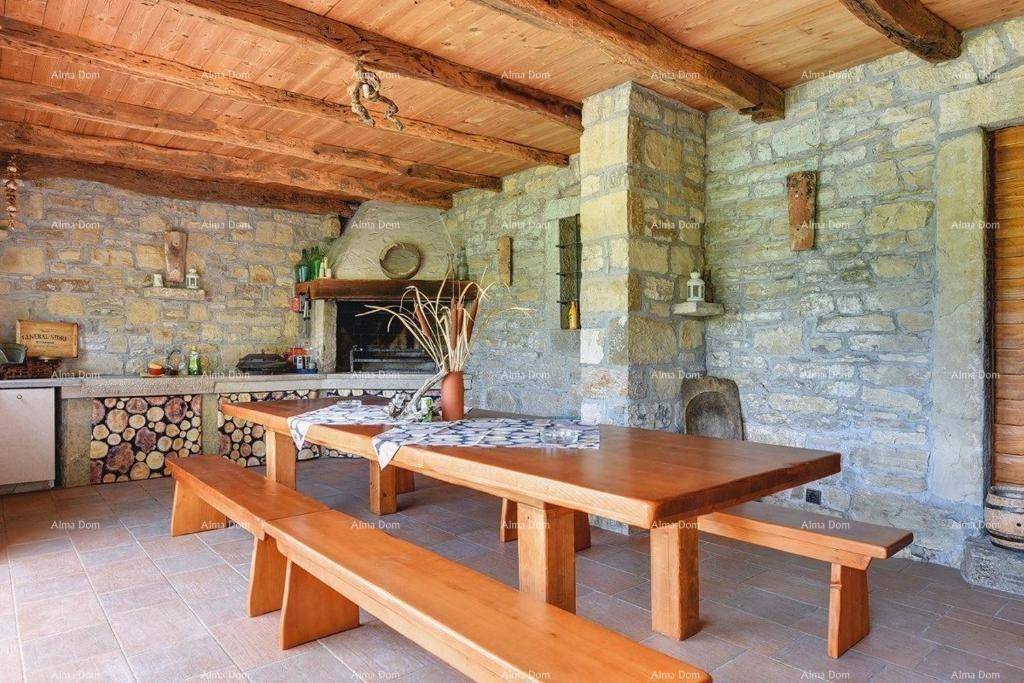 Rustikale Außenküche mit großem Holztisch und Bänken, integriertem Grill und Steinwänden für gesellige Abende.