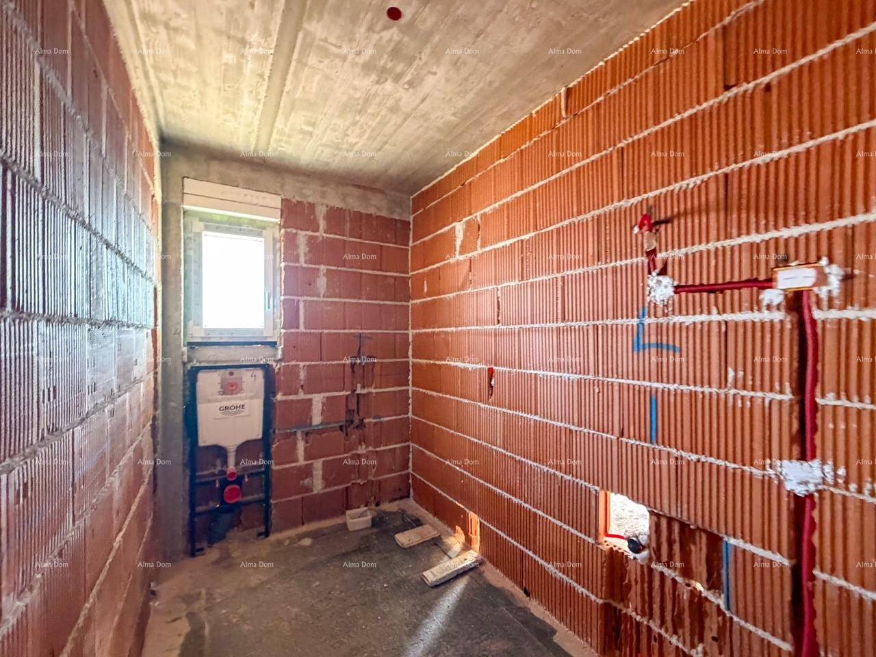 Badezimmer im Rohbau mit Ziegelwänden und vorbereiteter Installation für ein Wand-WC und Dusche.