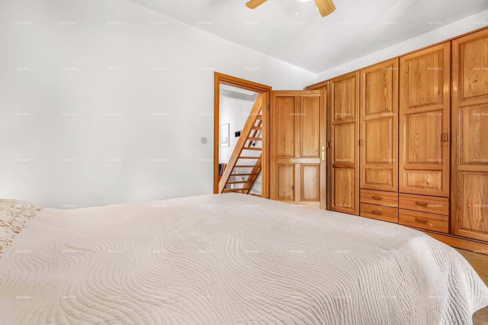 Schlafzimmer mit Doppelbett, großem Holzschrank und Zugang zu einem weiteren Raum.