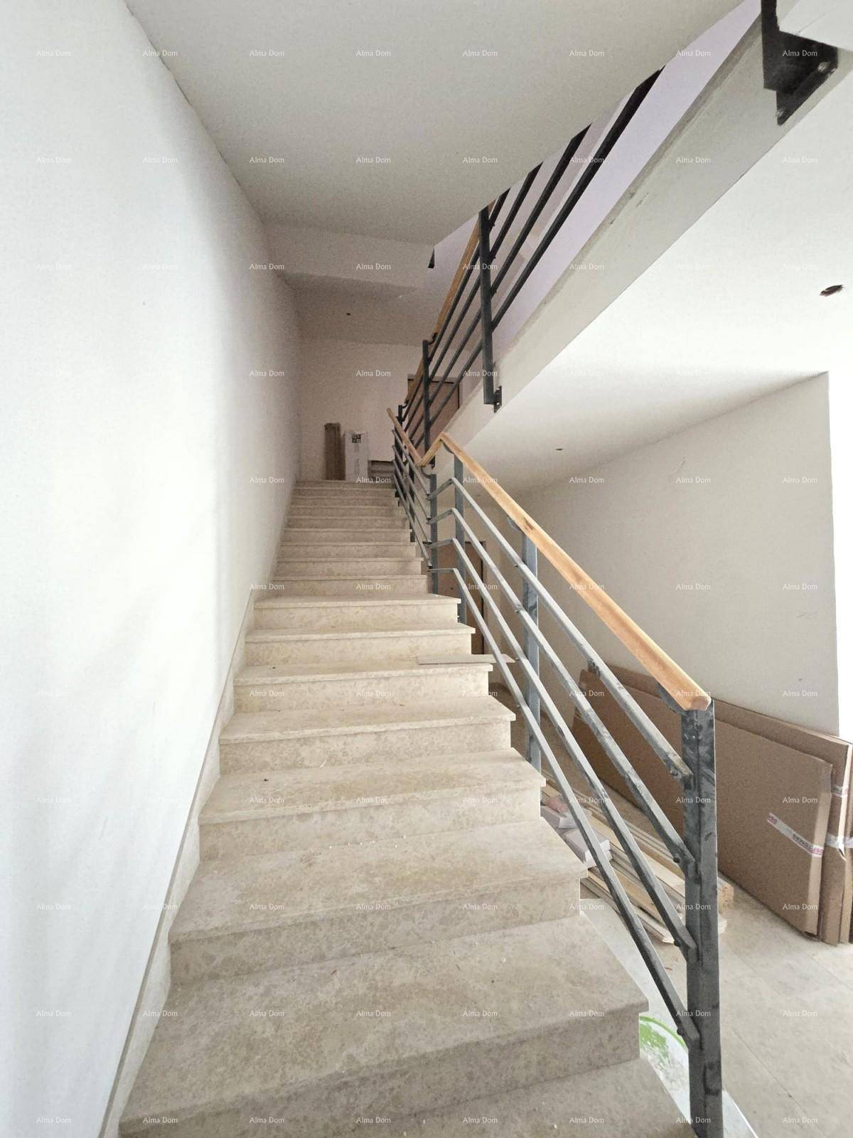 Helles Treppenhaus in einem Neubau mit Steinstufen und modernem Metallgeländer.