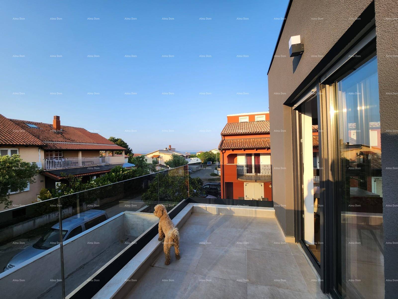 Großer Balkon mit Glasgeländer und weitem Blick über die Dächer der umliegenden Häuser.