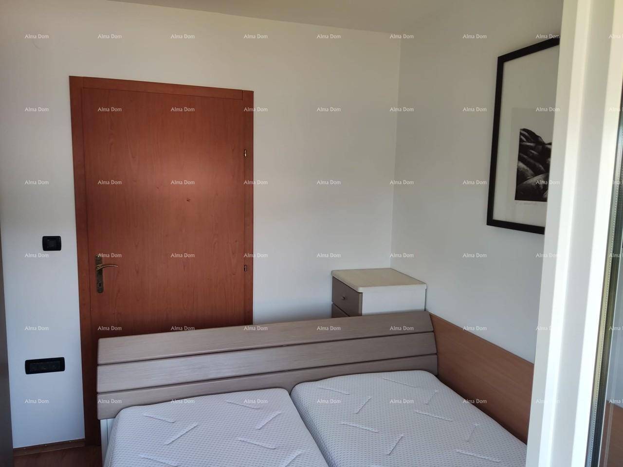 Schlafzimmer mit Holztür, Bett und schlichtem Nachttisch.