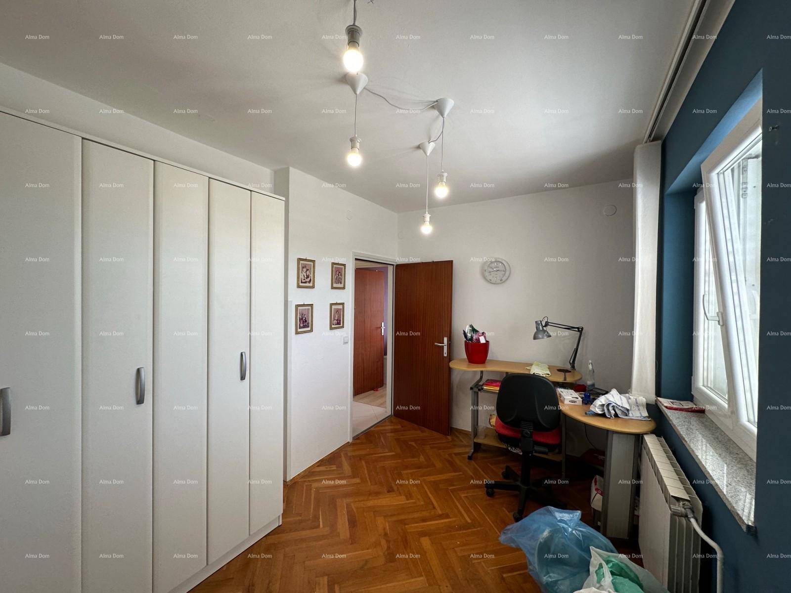 Helles Schlafzimmer mit blauer Wand, Fischgrätparkett und integriertem Arbeitsbereich.