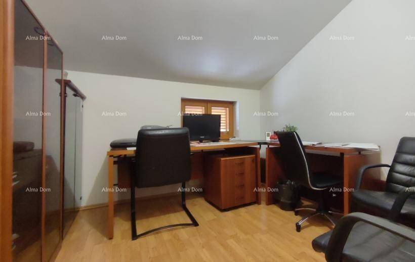 Arbeitszimmer mit Schreibtischen, Bürostühlen und Holzmöbeln unter Dachschräge.