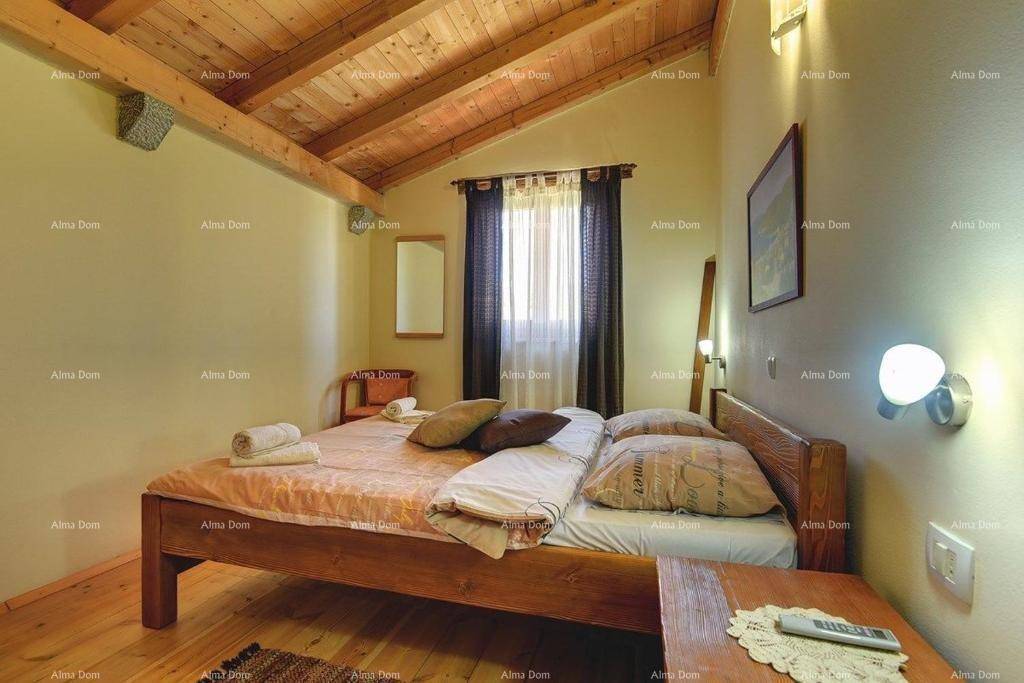Helles Schlafzimmer mit Holzbalkendecke, Holzboden und einem bequemen Doppelbett.
