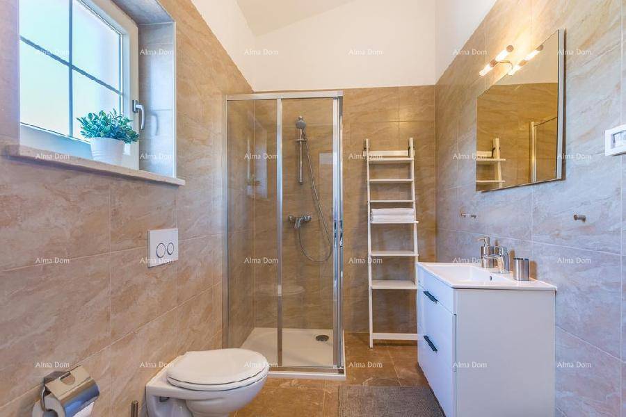 Modernes Badezimmer mit Duschkabine, WC, Waschbecken und beigefarbenen Fliesen.
