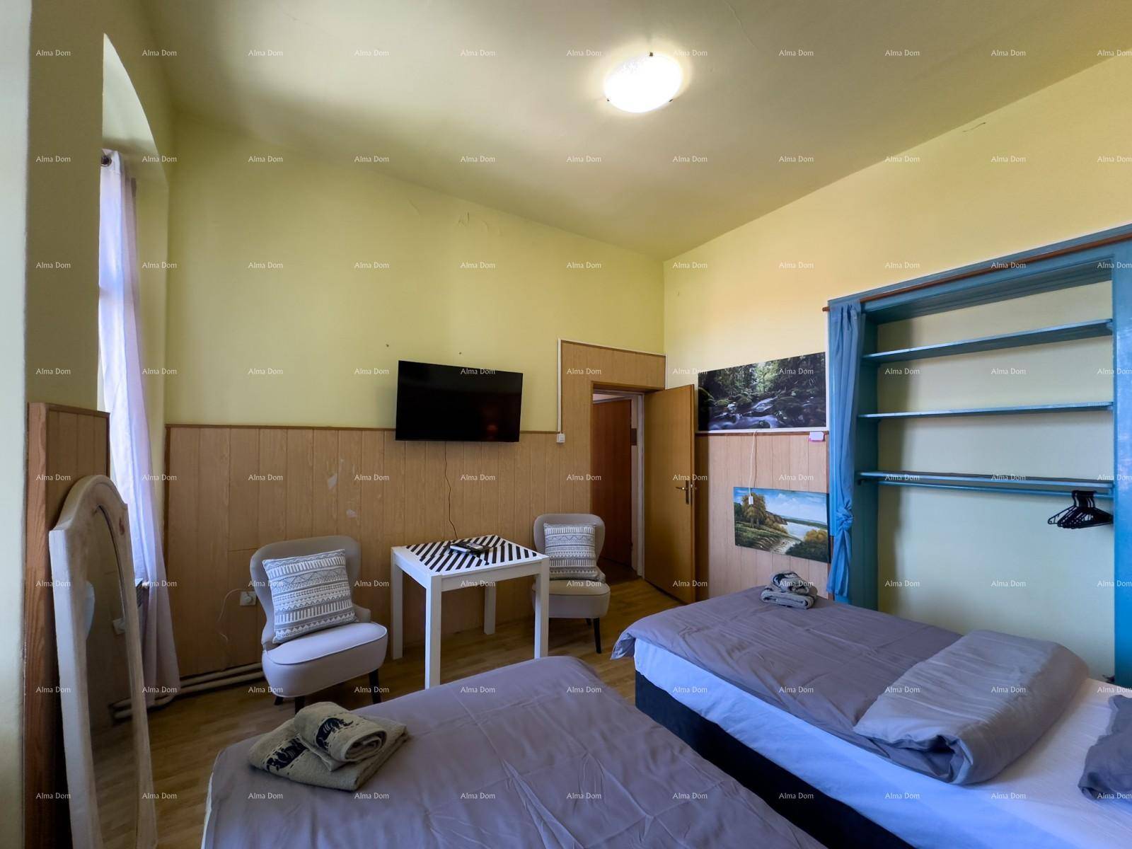 Schlafzimmer mit zwei Einzelbetten, Fernseher und Holzvertäfelung an den Wänden.