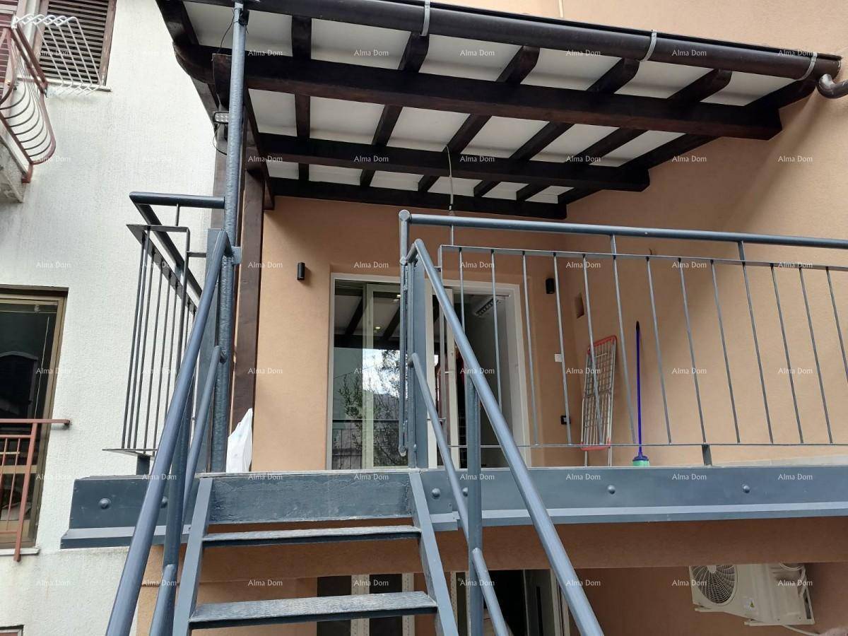 Überdachter Balkon mit Metallgeländer und Zugang über eine Außentreppe.