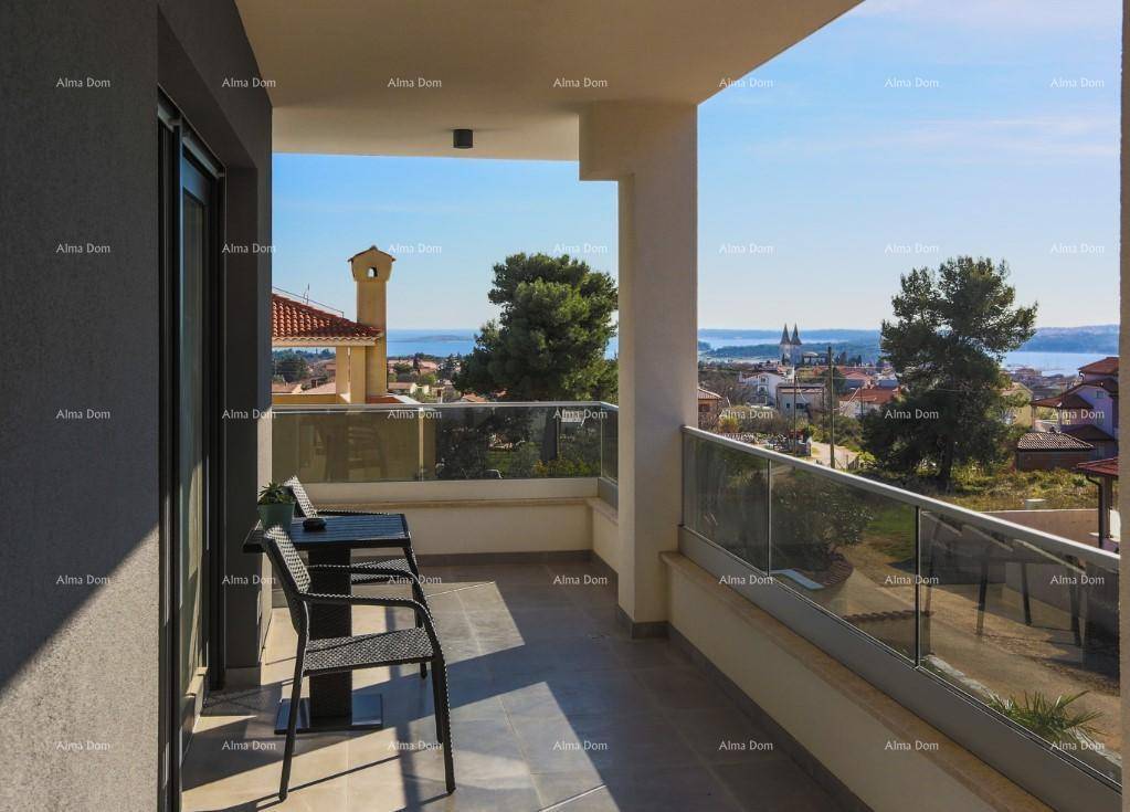 Balkon mit kleinem Tisch und Stühlen, bietet einen schönen Blick auf die Stadt und das Meer.