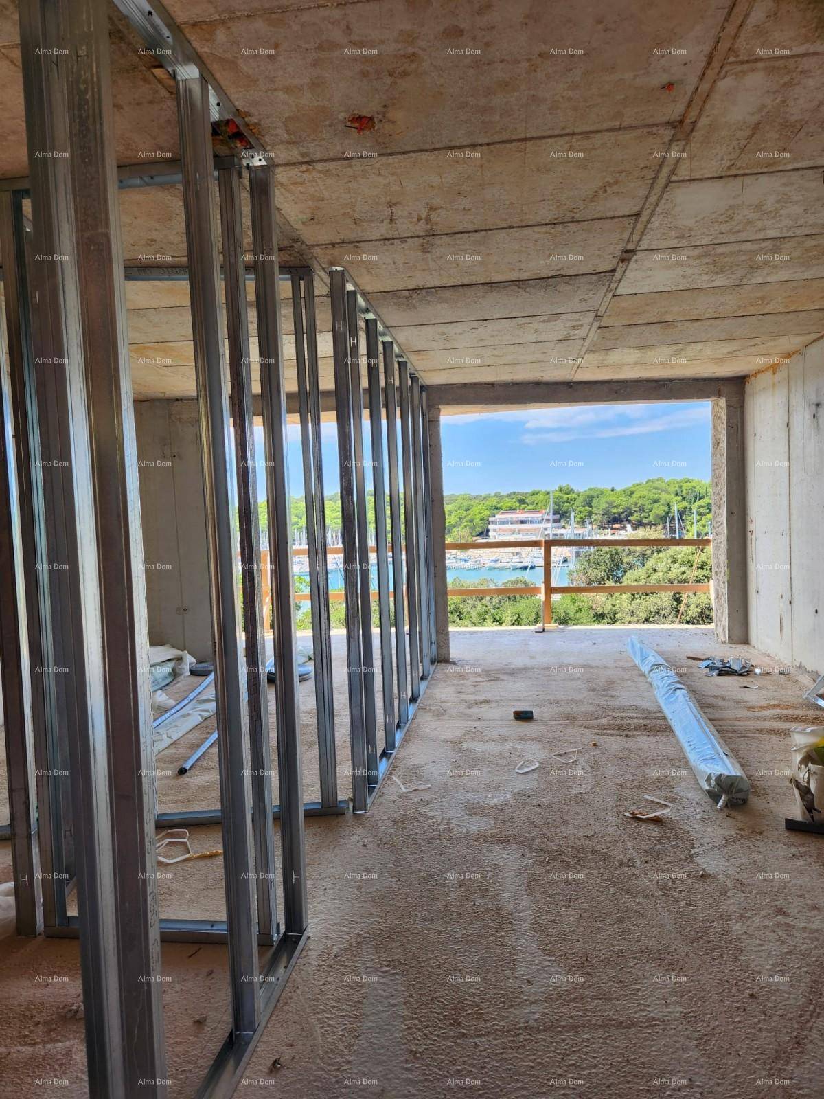Rohbau-Innenraum mit Metallständerwerk für Wände und weitem Blick auf den Yachthafen und die Natur.