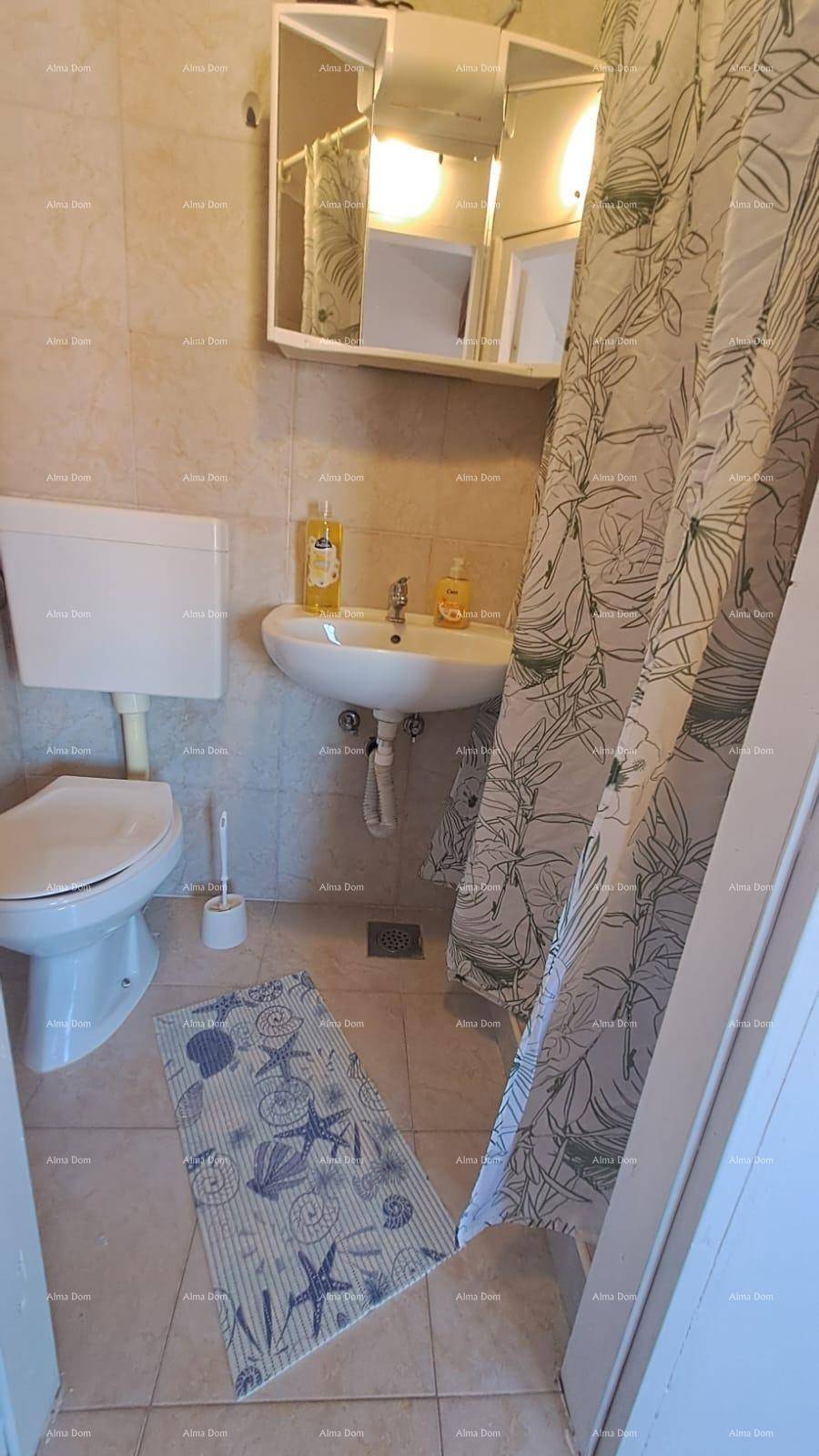 Funktionales Badezimmer mit Toilette, Waschbecken und Duschvorhang, komplett gefliest.