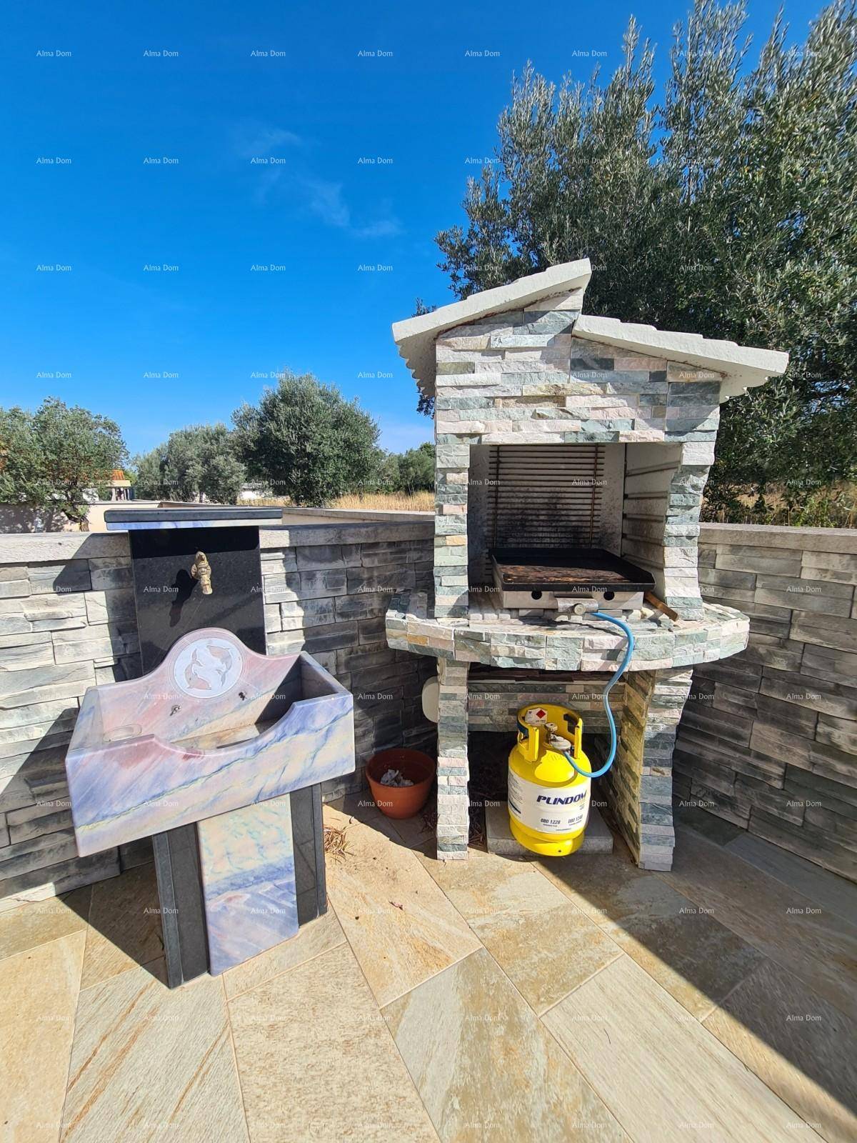 Gemauerter Grillplatz mit Spülbecken und Gasflasche für gemütliche Abende im Freien.