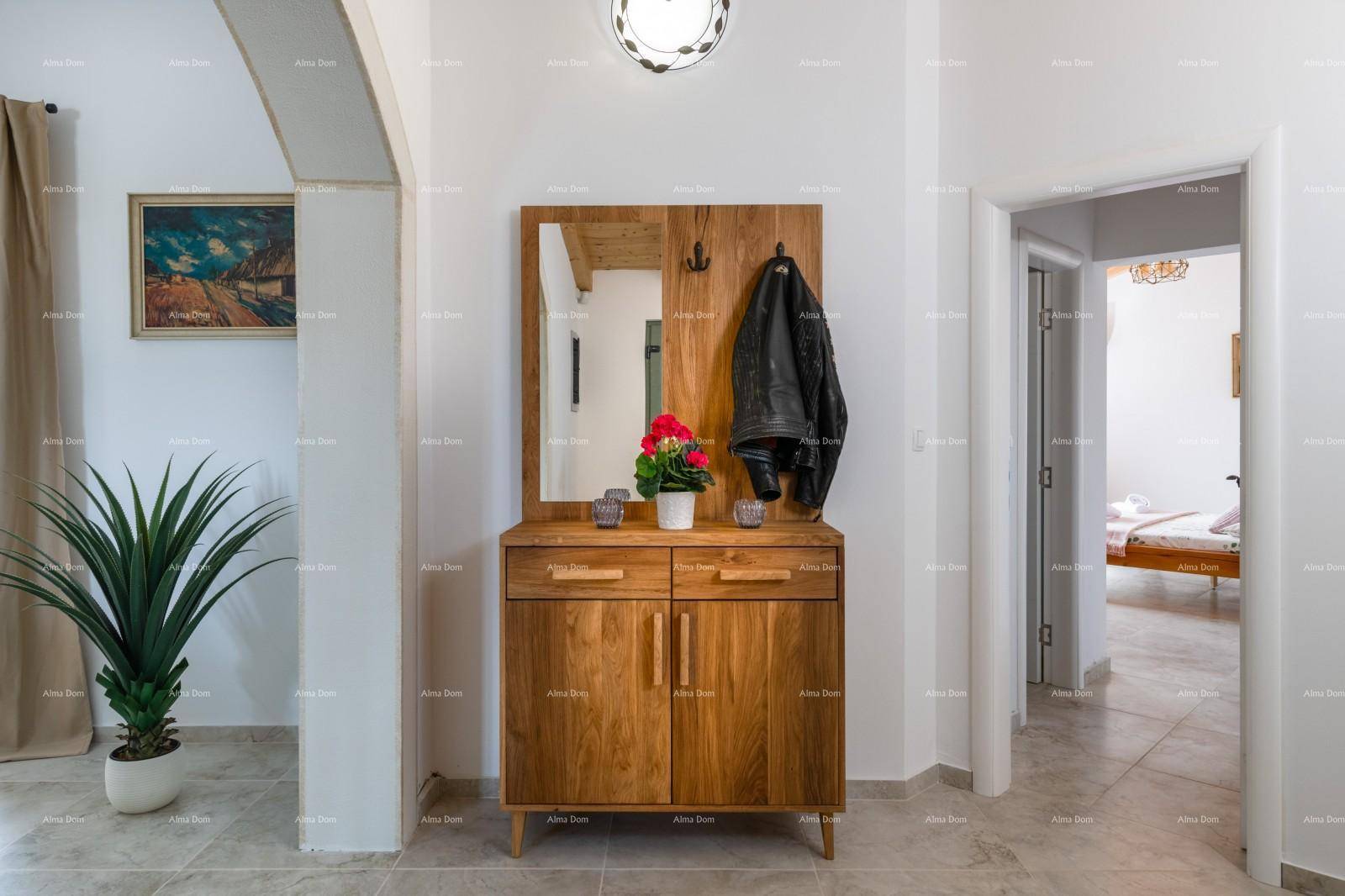 Heller Eingangsbereich mit Garderobe, Spiegel und Zugang zu weiteren Räumen.