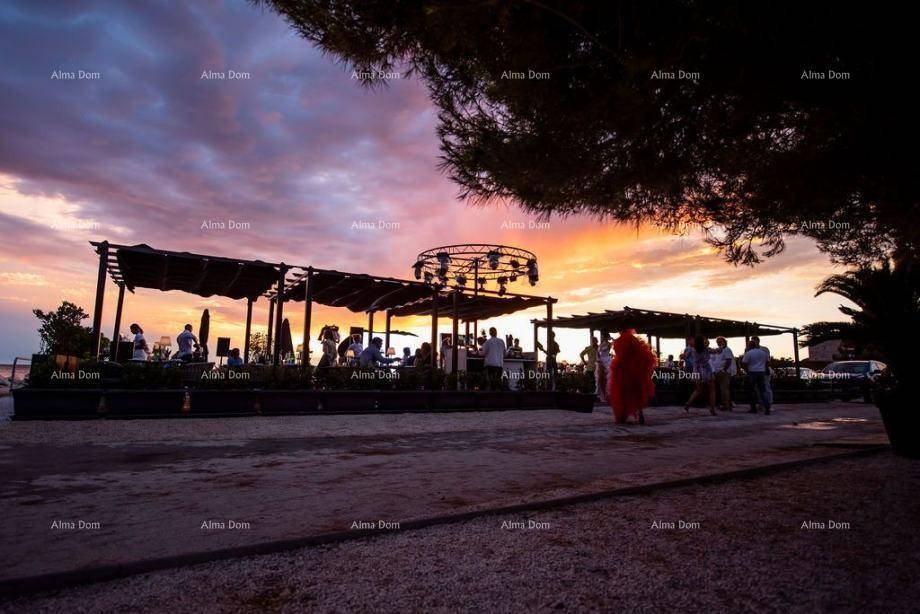Weitläufiger Außenbereich für Veranstaltungen oder eine Strandbar bei dramatischem Sonnenuntergang.
