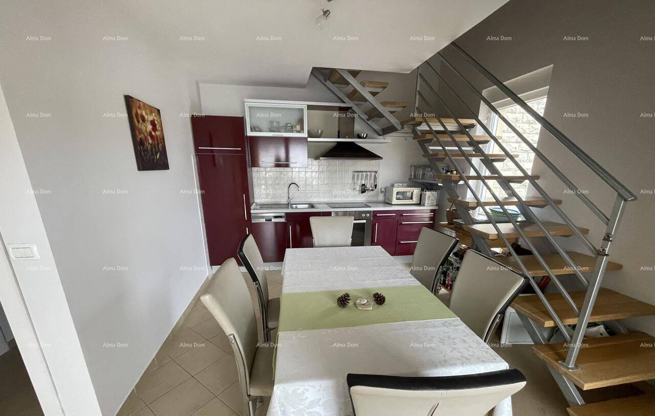 Gemütlicher Essbereich mit angrenzender Küche und einer offenen Treppe, die in die obere Etage führt.
