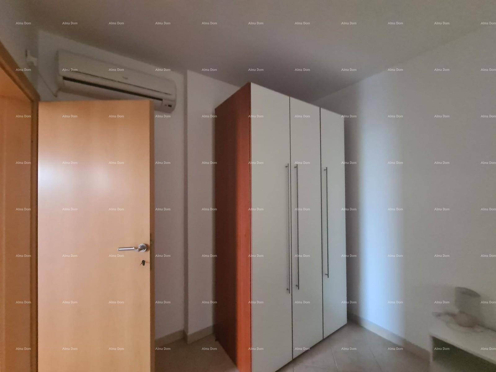 Schlafzimmer mit großem Kleiderschrank und Klimaanlage, mit Holztür.